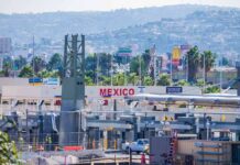 Border crossing booths at Mexico entry point with cityscape in background