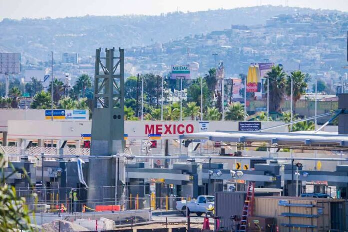 Border crossing booths at Mexico entry point with cityscape in background