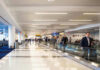 Airport terminal with passengers on a moving walkway