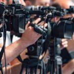 AOC Officially Joins Socialist Party Ahead Of 2028 Run television cameras on tripods at a media event