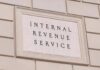 Tax-The-Rich Crusader Candidate Hit With IRS Tab Internal Revenue Service building sign on a stone wall
