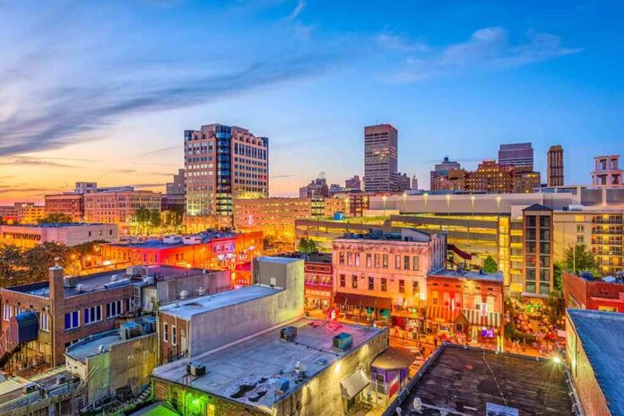 shutterstock_1078695767 City skyline at dusk with lit streets and buildings