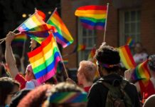 162 LQBTQ ARRESTED in Midnight Raid Crowd waving rainbow flags at an outdoor event
