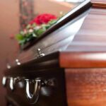 Model Heir Found Dead In Rehab At 27 Wooden casket with floral arrangement