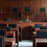 Maniac Storms Into Courthouse With Loaded Gun! Empty courtroom with wooden benches and judge's bench