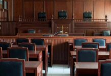 Maniac Storms Into Courthouse With Loaded Gun! Empty courtroom with wooden benches and judge's bench