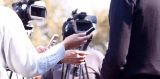press interview with microphones and cameras outdoors
