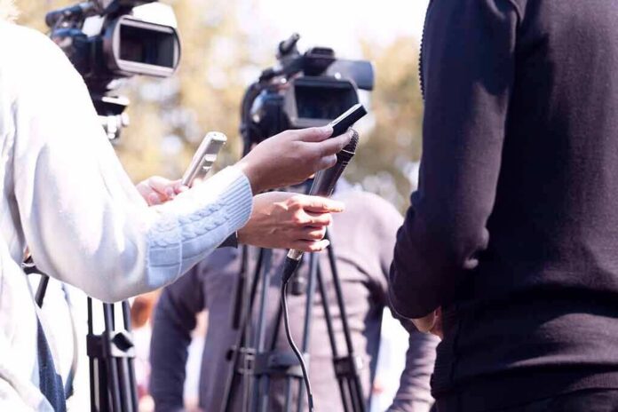 press interview with microphones and cameras outdoors