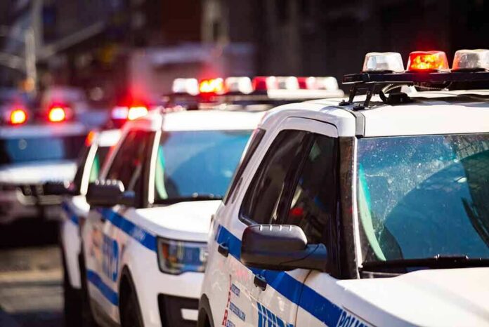 shutterstock_1375359047 police cars with flashing lights on a city street