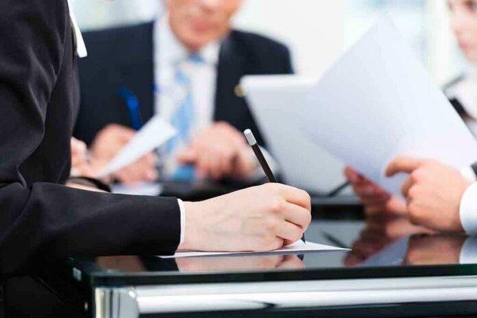 Close-up of a hand writing notes during a business meeting
