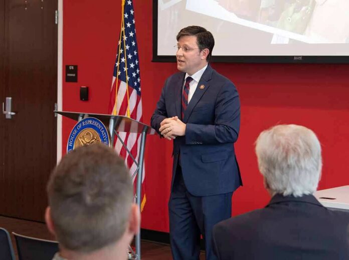 shutterstock_1381036310-1 Speaker in a navy suit addressing an audience at a podium
