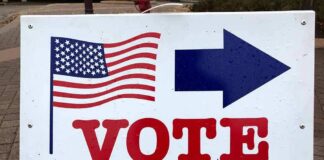 voting sign with arrow and American flag