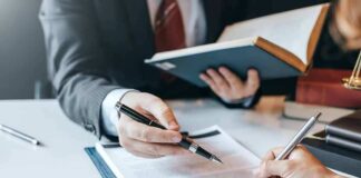Hands signing a legal document at a desk