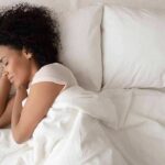 Woman sleeping on white bedding