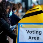 Dem Senators REVOLT — Prepare to Switch Parties voter wearing a mask using a yellow ballot box