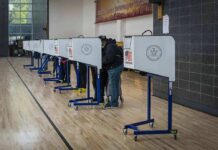Radical Far-Left Afghani Wins US House Special Election Voters at polling booths in a gymnasium