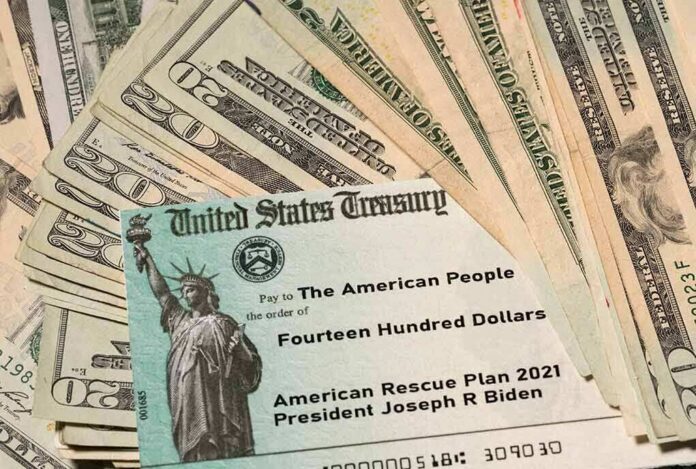 shutterstock_1931065187 U.S. Treasury check on top of scattered dollar bills