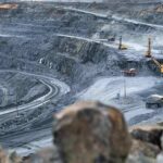 Open-pit mine with haul trucks and excavators on terraced roads