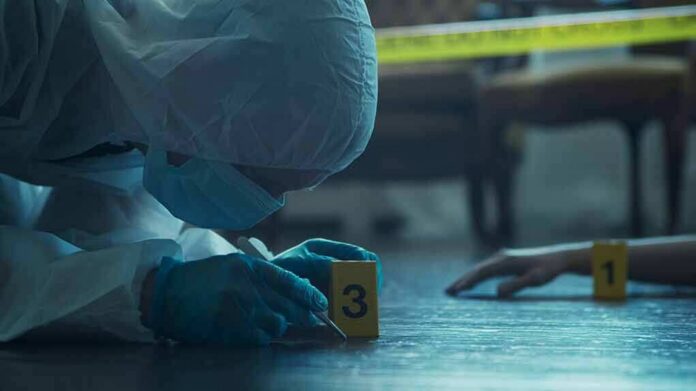 shutterstock_2196208523 forensic investigator in protective suit examining crime scene markers