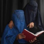 Move to Ban Burkas and Niqabs in Schools Underway Two veiled women reading a red book together