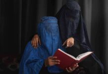 Move to Ban Burkas and Niqabs in Schools Underway Two veiled women reading a red book together