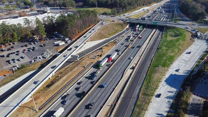 shutterstock_2268382443 Aerial view of multi-lane highway interchange with overpass and traffic