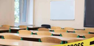 Empty classroom with police tape across desks