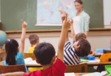 Students raising hands in a classroom