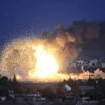 Large explosion over a city at night