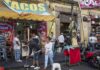 Food Truck Workers BOLT From ICE During Immigration Raid Street taco stand with people and a religious statue on a sidewalk