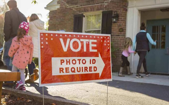 Red voting sign with arrow near people entering a polling place