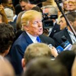 Donald Trump speaks to reporters in a crowded media scrum