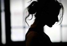 silhouette of a woman in profile against a bright window
