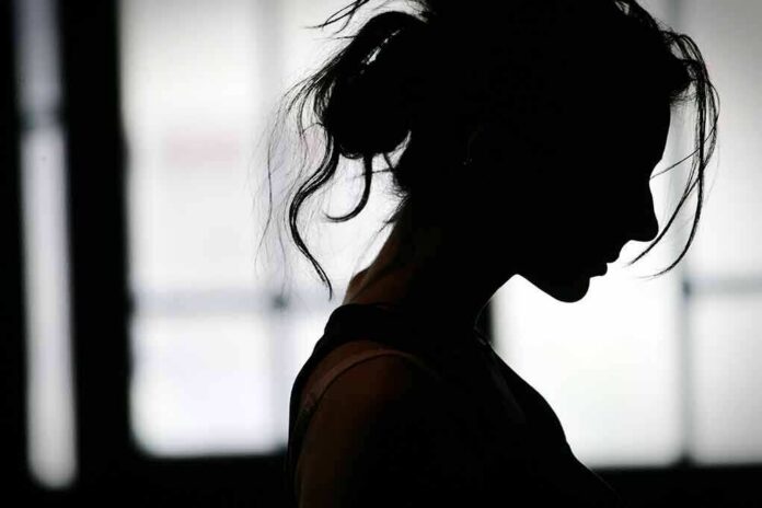 silhouette of a woman in profile against a bright window
