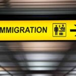 Government Warns Of Civil War Plot Against Migrants Immigration sign with arrow in airport