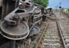 Overturned train cars beside railway tracks