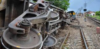 Overturned train cars beside railway tracks