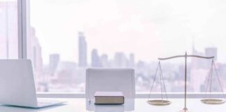law office desk with laptop book and scales of justice