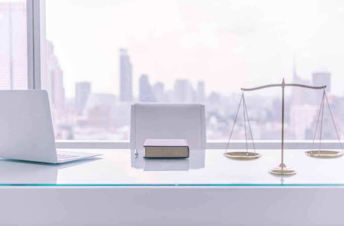 law office desk with laptop book and scales of justice