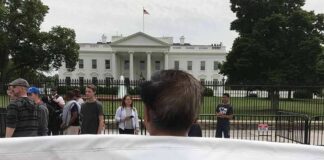 Protester holding a large banner in front of the White House