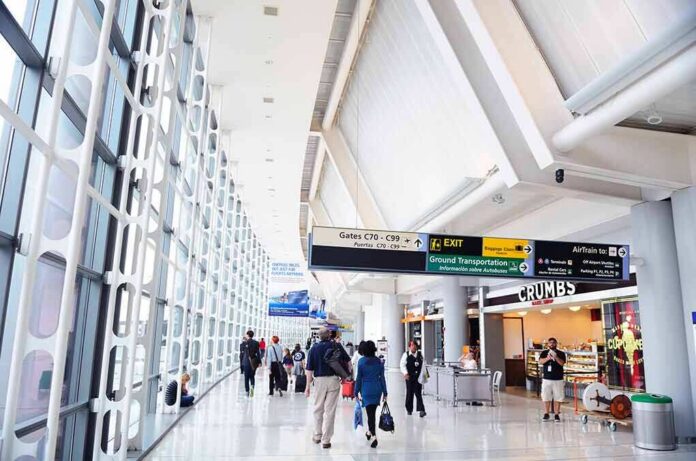 shutterstock_99344561 Airport terminal hallway with travelers and signage