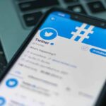 New White House Press Sec Comes With BAGGAGE Smartphone displaying Twitter app on a laptop keyboard