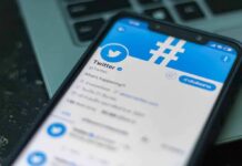 New White House Press Sec Comes With BAGGAGE Smartphone displaying Twitter app on a laptop keyboard