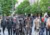 group of masked protesters walking through a city street