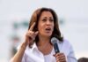 Kamala Harris speaking into a handheld microphone outdoors
