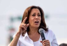 Kamala Harris speaking into a handheld microphone outdoors