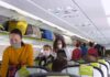 Passengers with masks boarding an airplane cabin