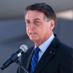 Brazil Election Heads to Run-Off After No Majority Vote man in suit speaking at a microphone
