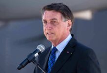 man in suit speaking at a microphone