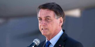 man in suit speaking at a microphone